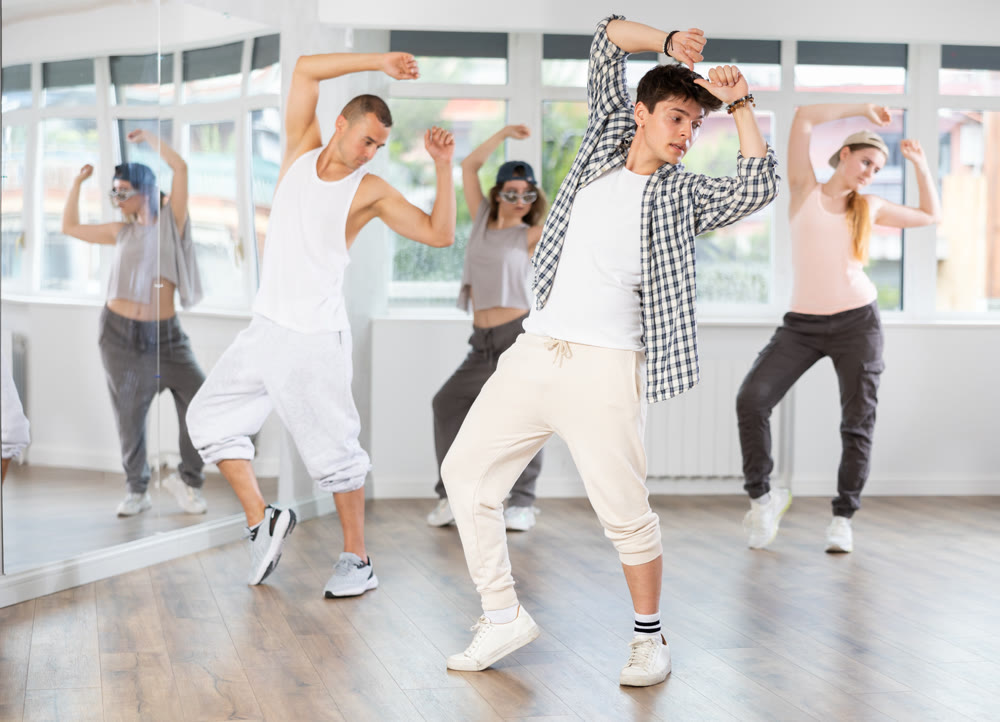 Active group sporty people practicing hip-hop dance in training hall during dancing classes