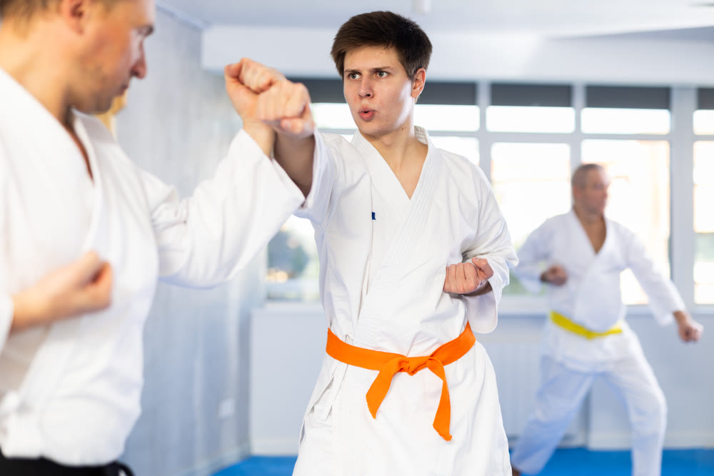 Adult and young men training karate fight