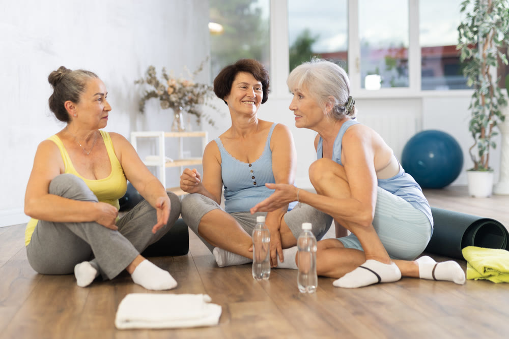 Group of elderly women talking in fitness studio