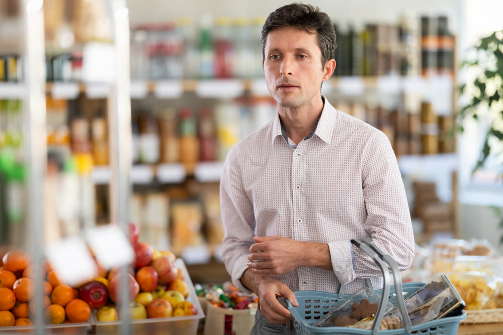 Adult man choosing food in grocery store