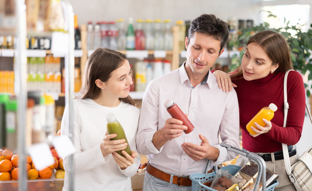 Family with teenage girl choosing smoothie in grocery