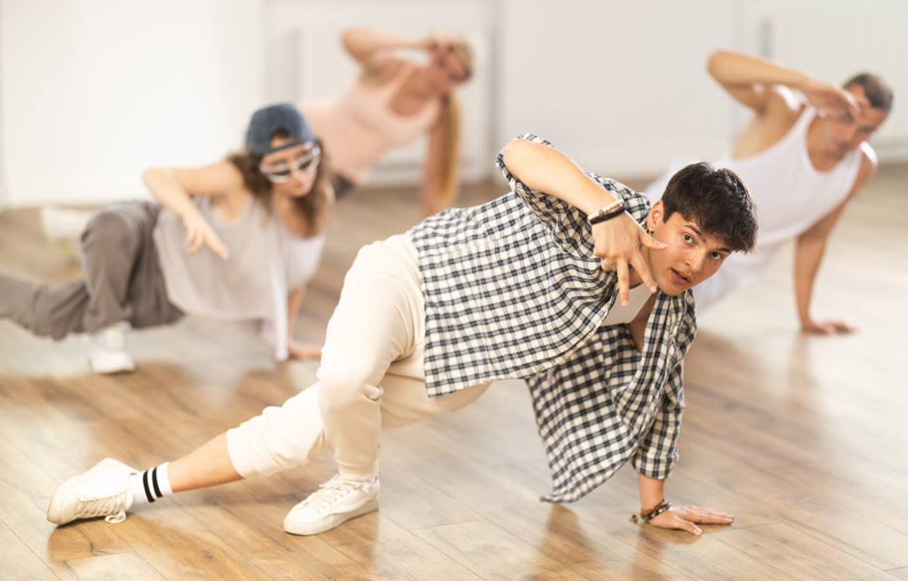 Young guy practicing breakdance floor-works in training hall