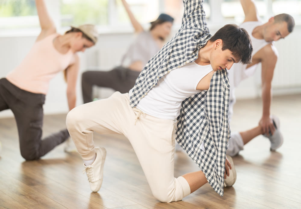 Young guy practicing breakdance in training hall
