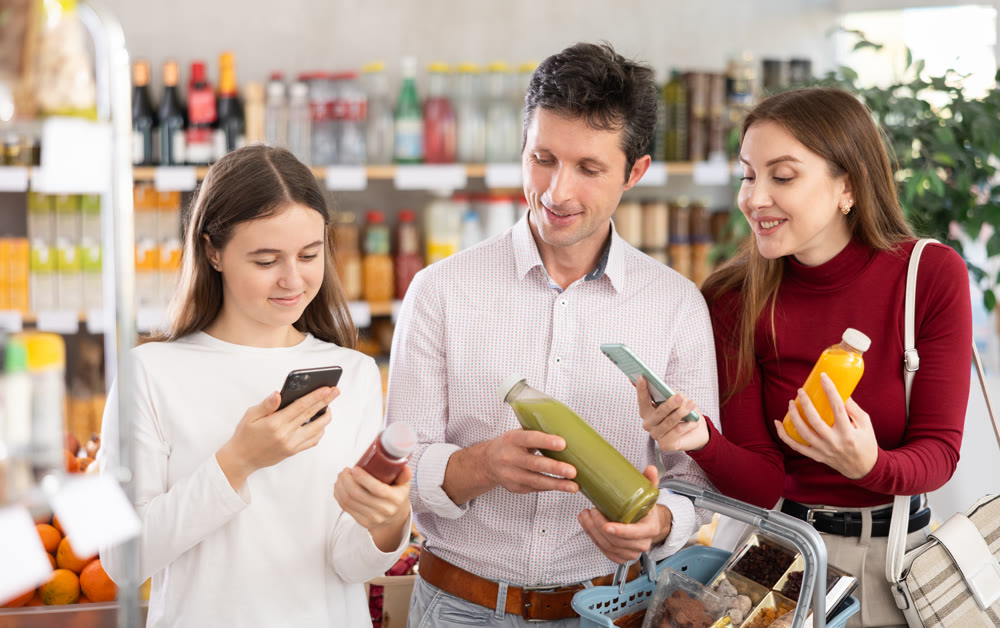 Family of buyers scans QR code on smoothie fruit mix cocktail packaging
