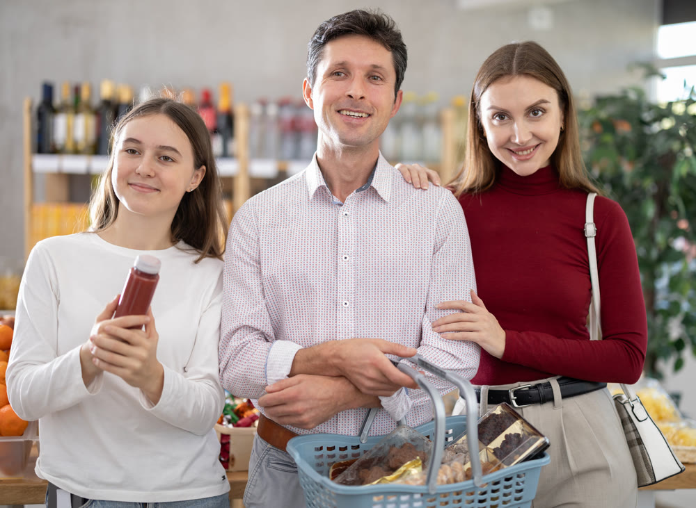 In store, family with purchases in hands looking for something on shelf of showcase