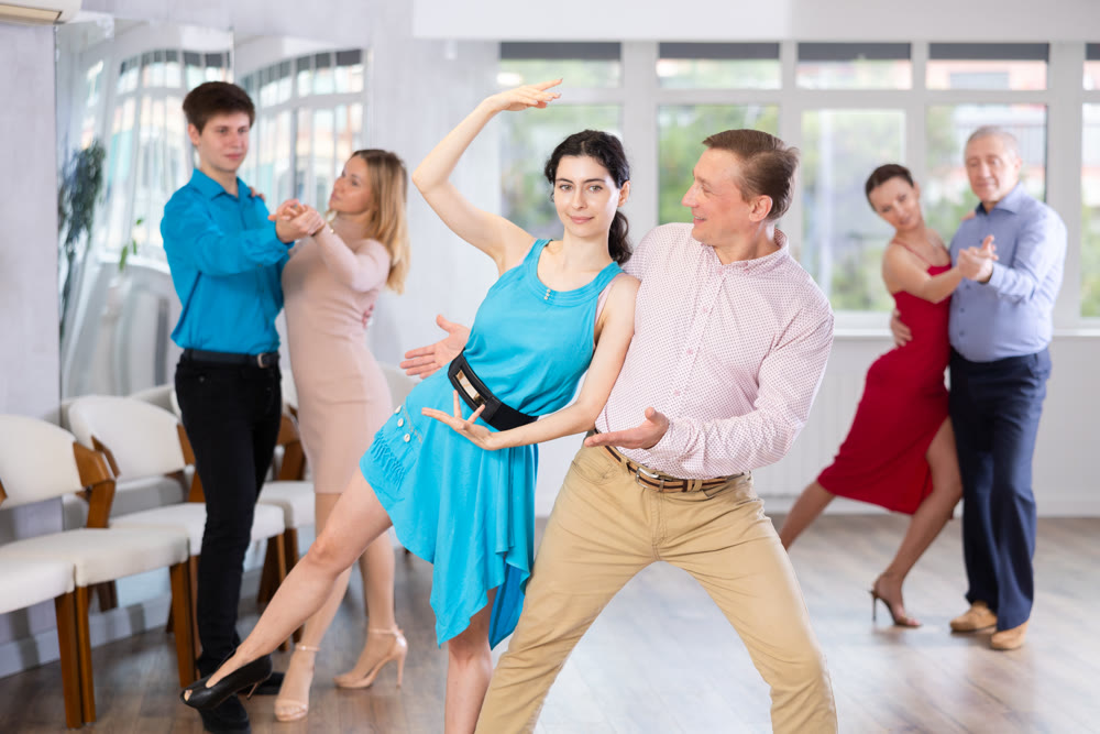 Smiling couple showcasing support during dance in choreography studio