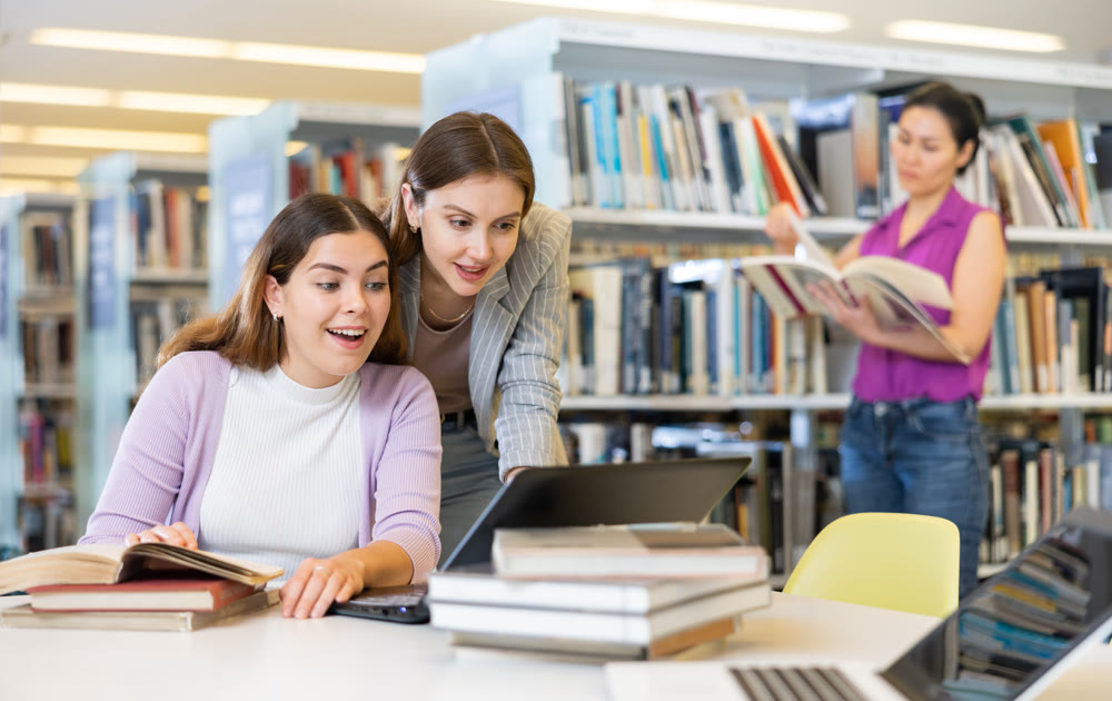 Two female students are preparing for the exam in the library