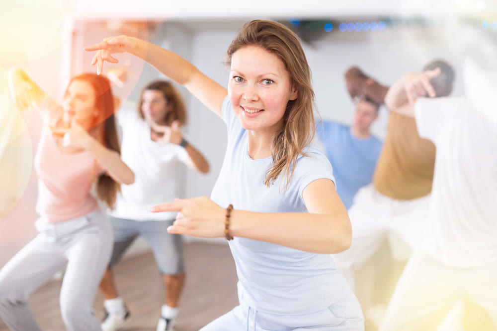 Females and males doing dance workout during group classes in fitness center