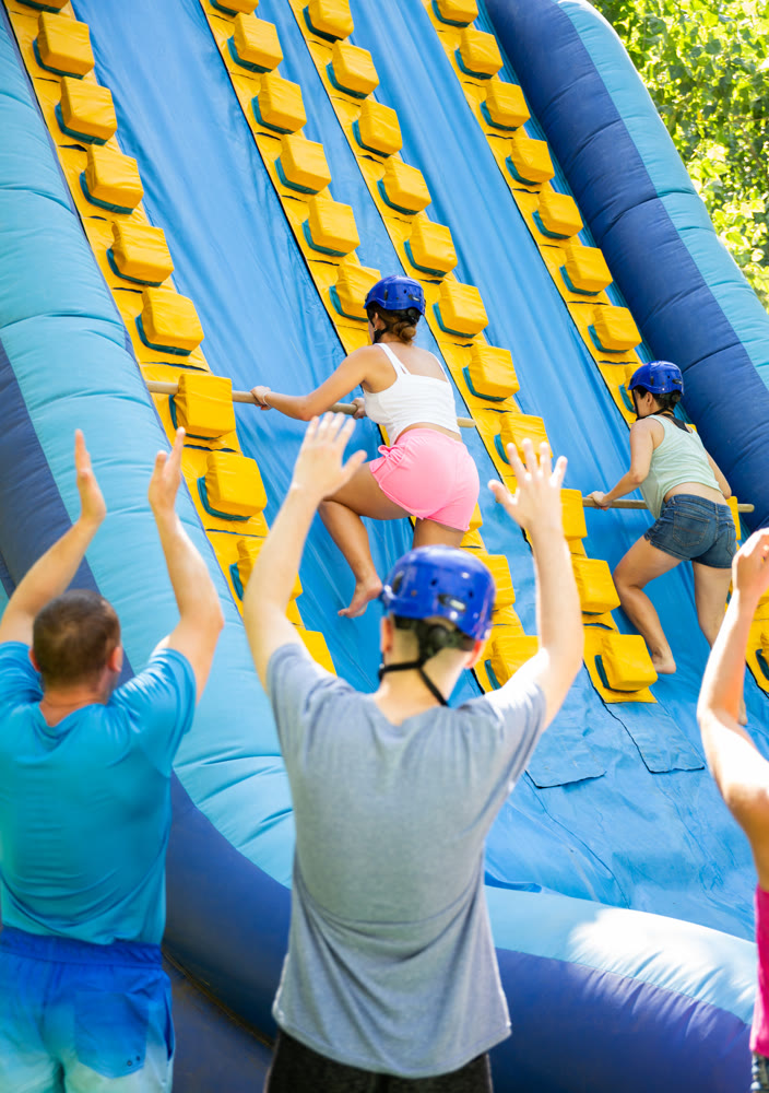 Women trying to climb on top of slide in amusement park