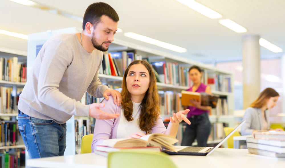 Man recommending books to woman in public library