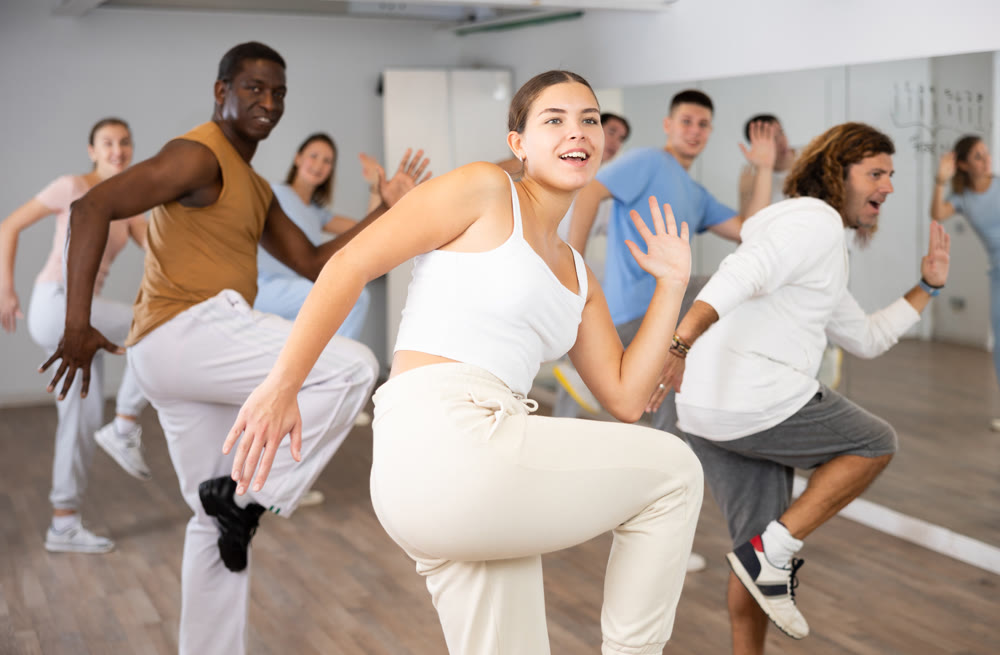 Group of different people rehearsing dance in dance studio
