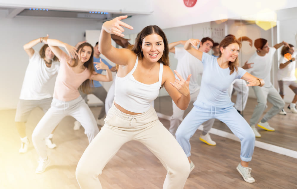 Group of smiling people of different ages dancing and practicing new movements in class. Sport, dance and urban culture concept