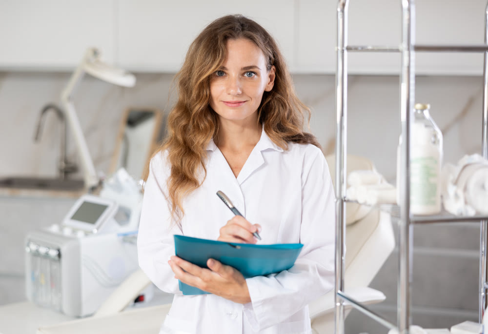 Young female doctor taking notes in medical room