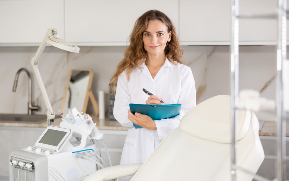 Portrait shot of doctor holding clipboard in hand while standing in medical esthetic office
