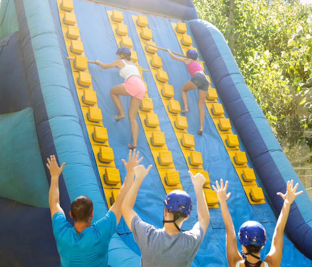 Women trying to climb on top of slide in amusement park