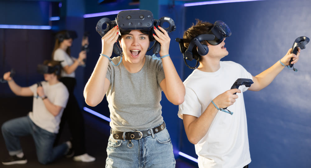excited girl took off his virtual reality helmet to take little rest while VR play with brother