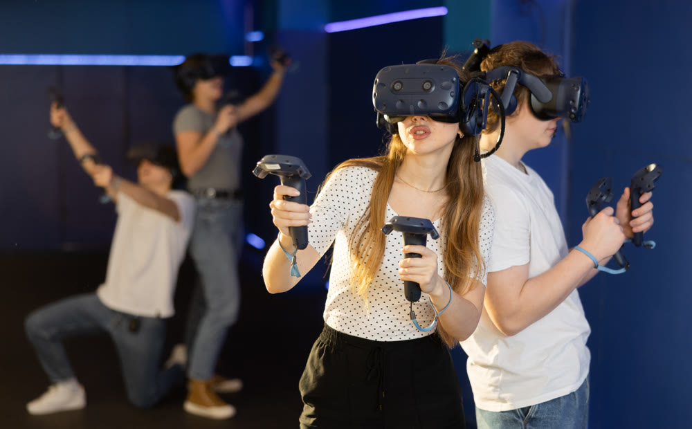 Young guy and girl in vr headset stand shoulder to shoulder interacting with digital interface