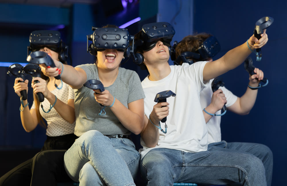 Modern people wearing virtual reality headset playing video games together
