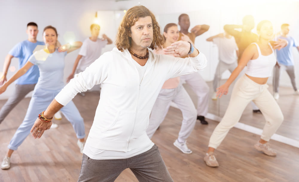 Group of different people rehearsing dance in dance studio