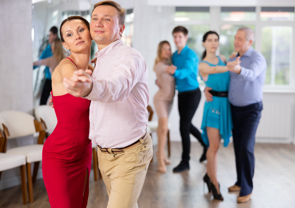 Woman and man learning to dance Vienneze waltz in dancing class