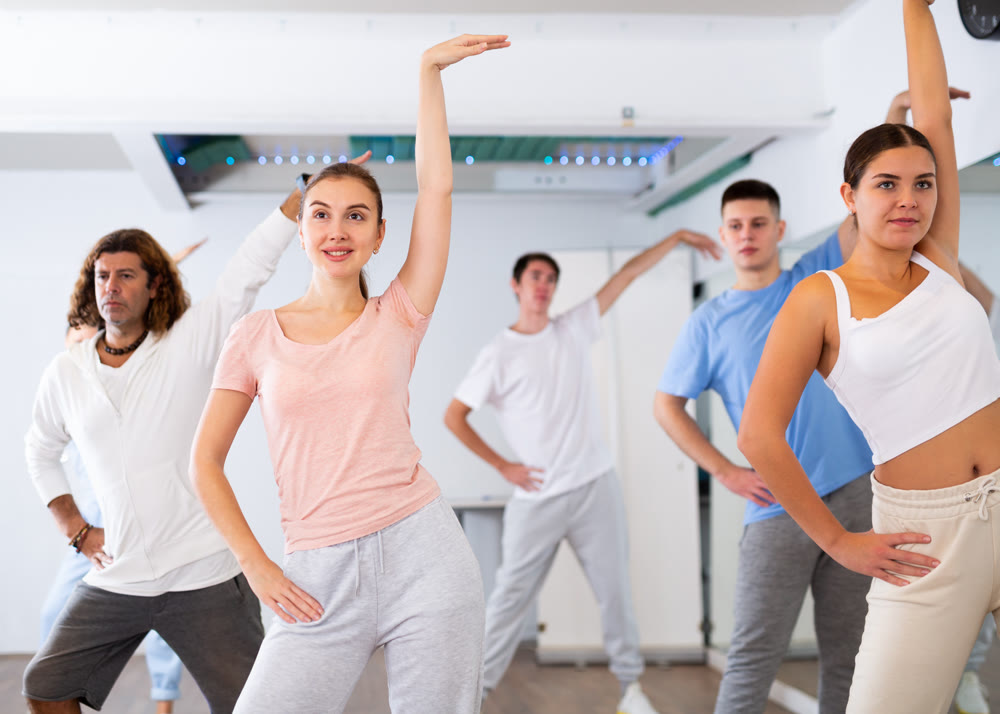 Group of different people rehearsing dance in dance studio