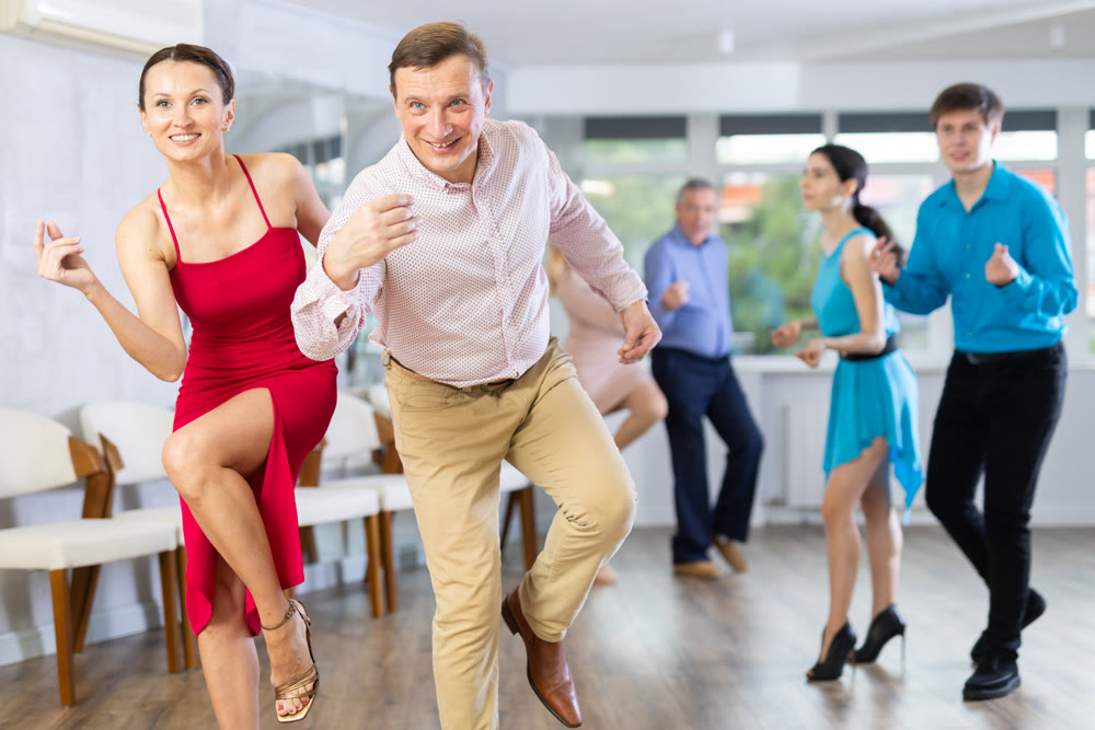 Dynamic pair engaging in Latino dance in dance studio. Pairs training ballroom dance in studio