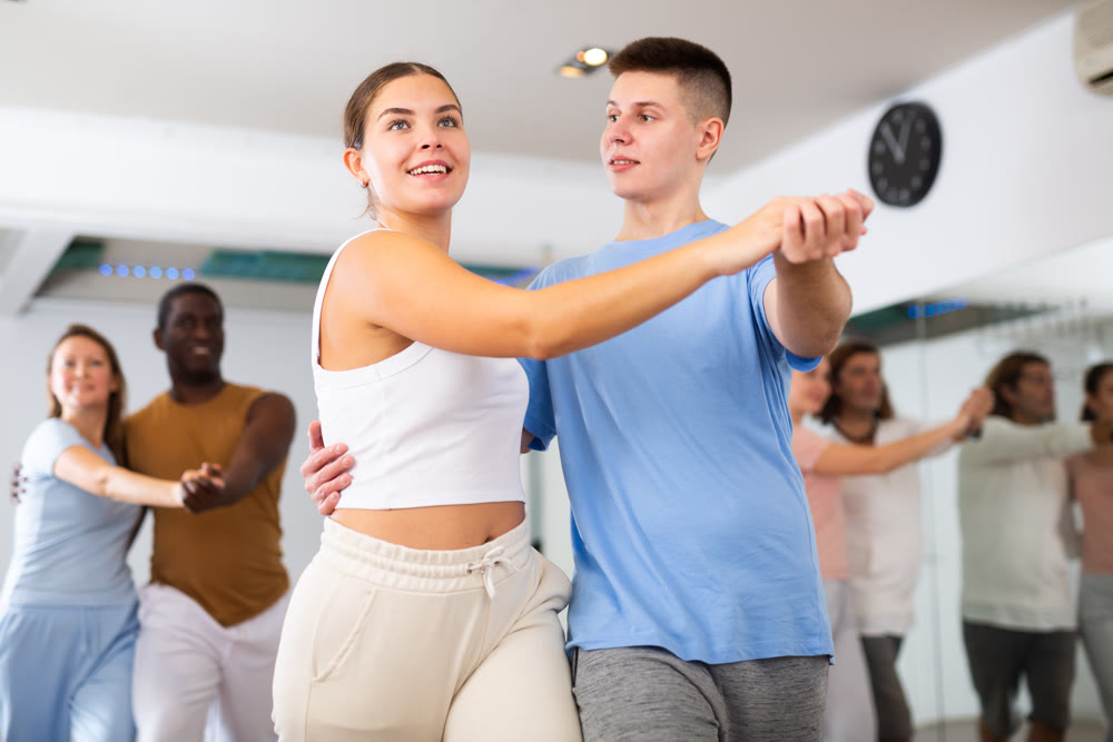 Young woman and teen boy dancing pair dance