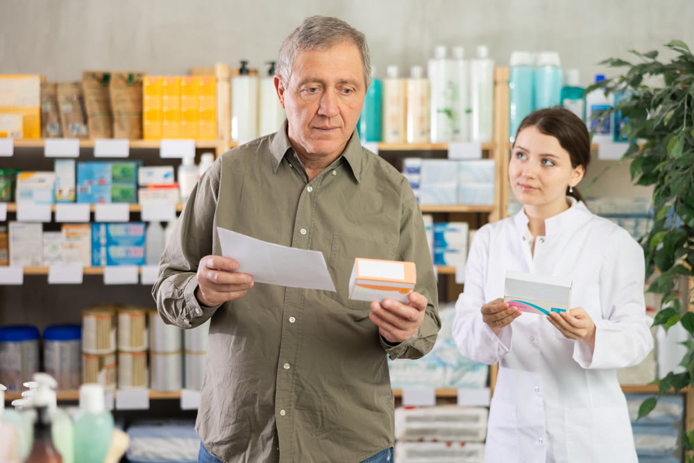 Man choosing pills with help from pharmacist