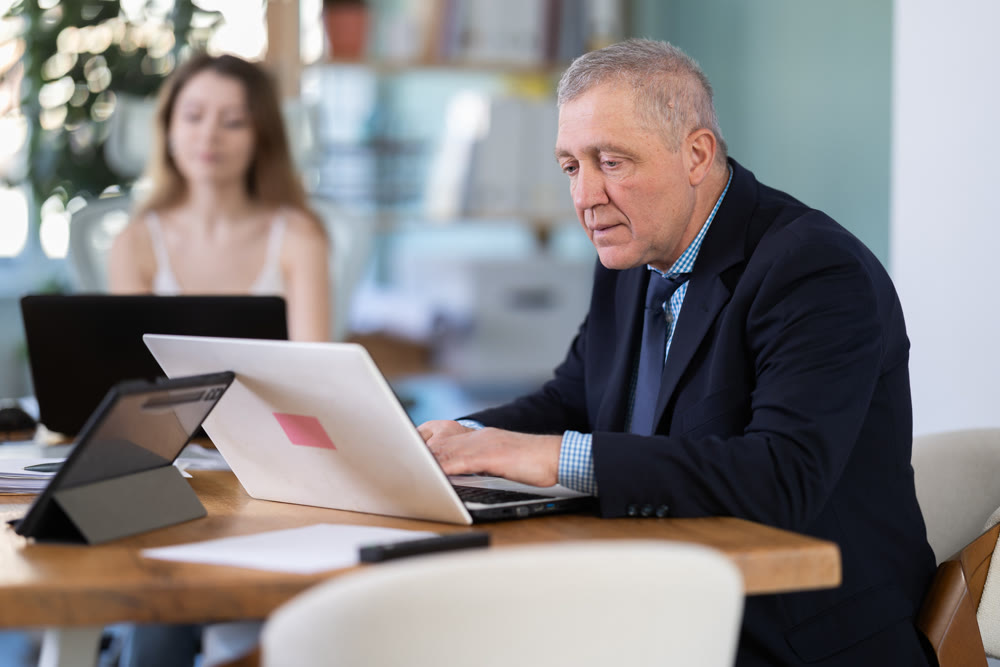 Elderly man and young woman working in office