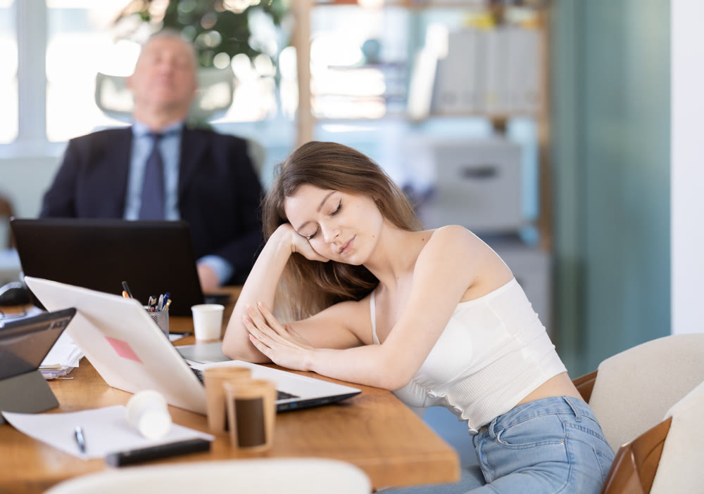 Tired man and woman sleeping in the office with her head on table