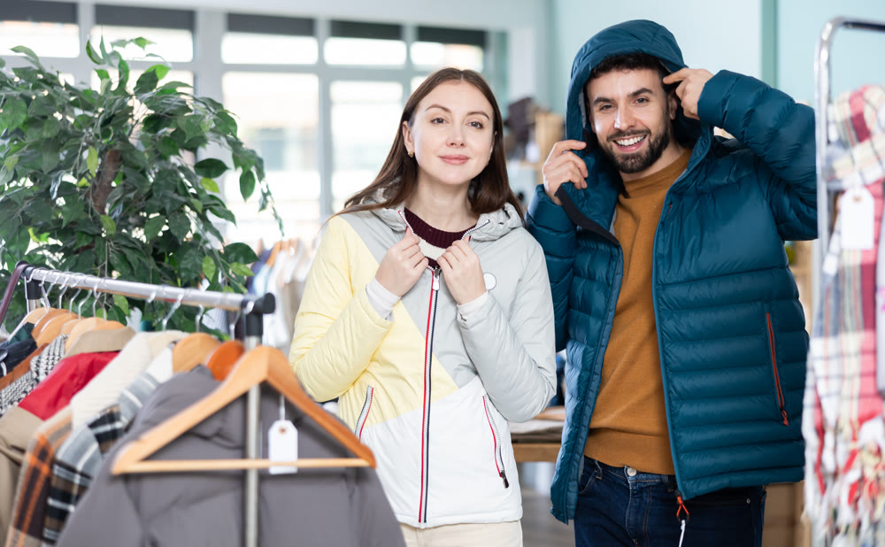 Couple trying on jackets in a clothing store