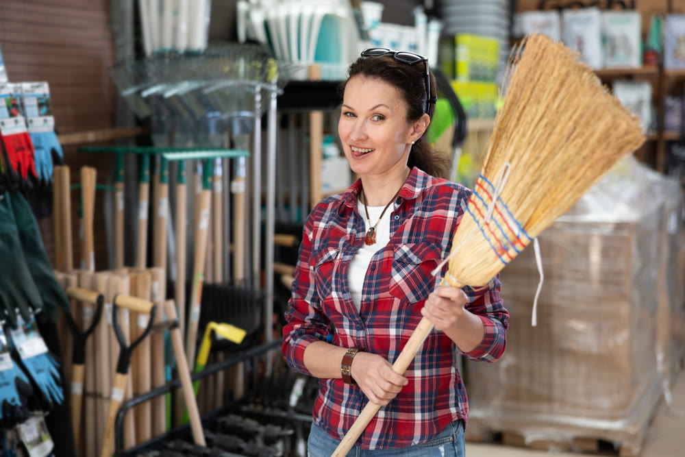 Woman shopping at hardware store - choosing broom