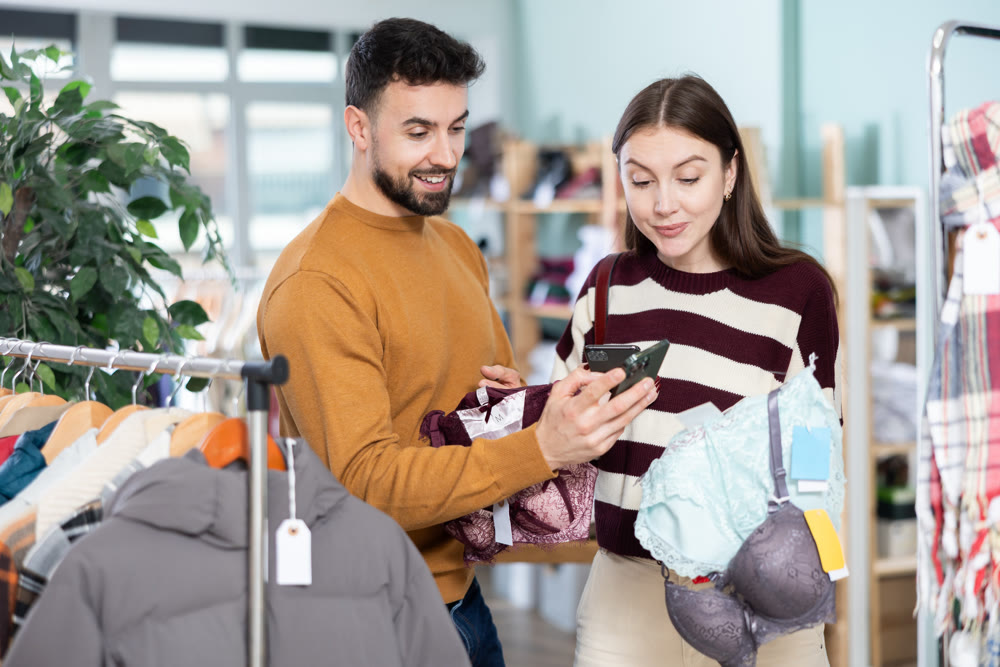 Couple choosing lingerie and scanning labels on mobile