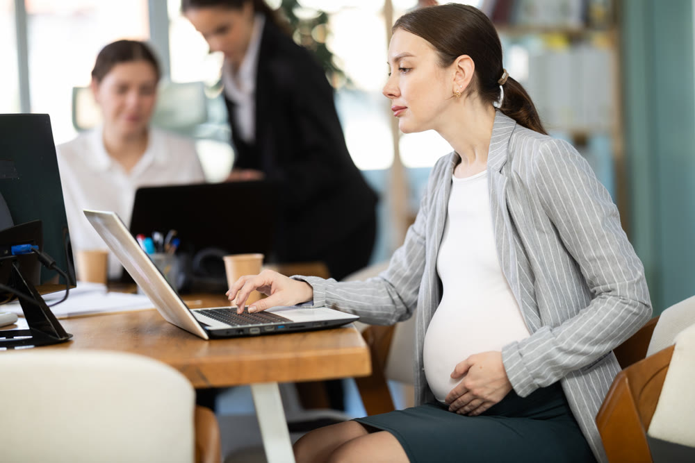 Pregnant woman working on laptop in office