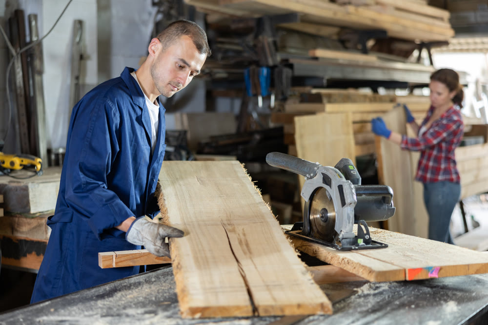 Young man puts oak plank on table