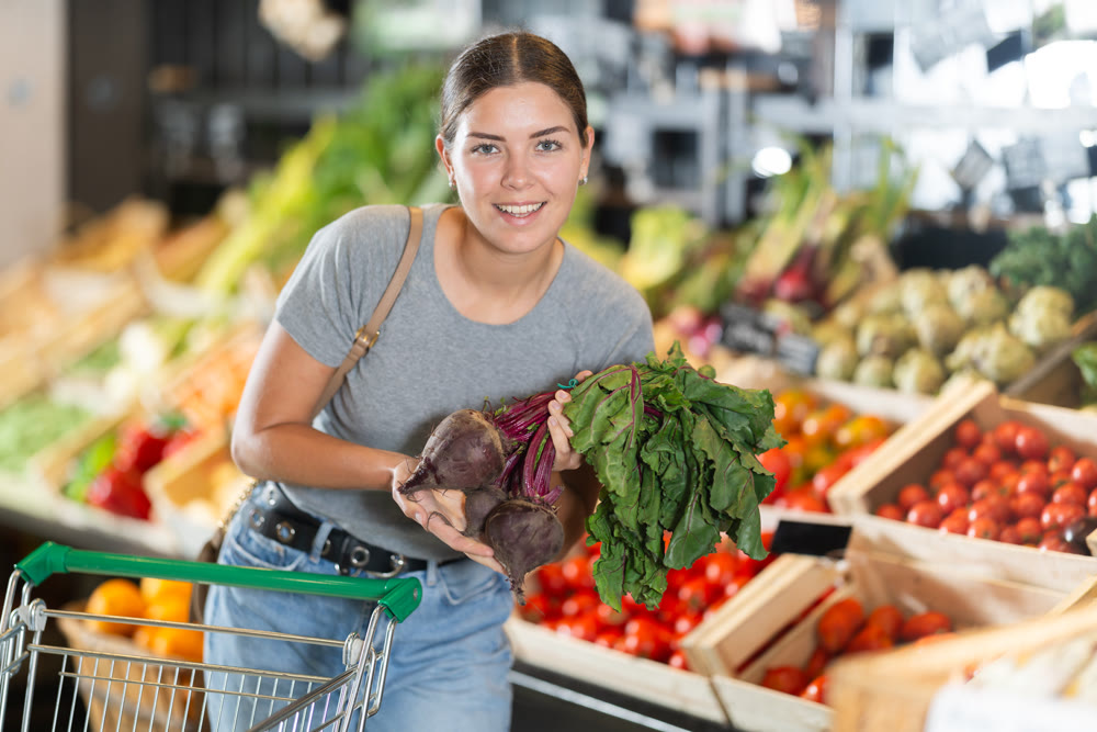 Young girl purchaser buying beetroots in grocery store