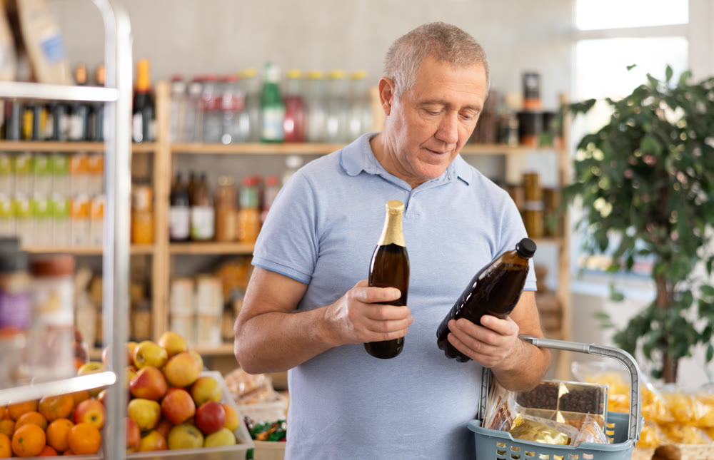 Mature man is choosing beer in grocery store