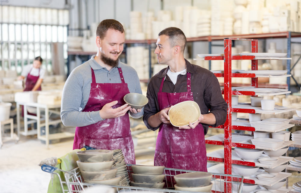 Two potters discussing handcrafted ceramic wares in studio