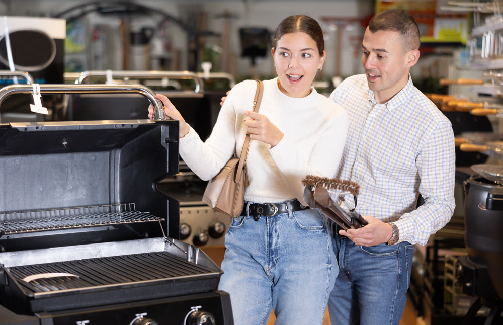 In store, married couple inspect mobile grill, buys barbecue device