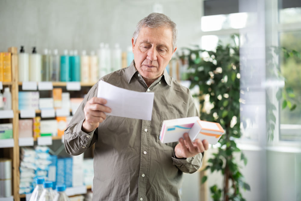 Elderly Man With Medical Prescription And Pills