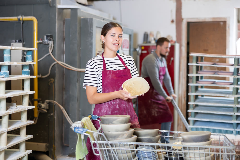 Young woman posing with ceramic dishes