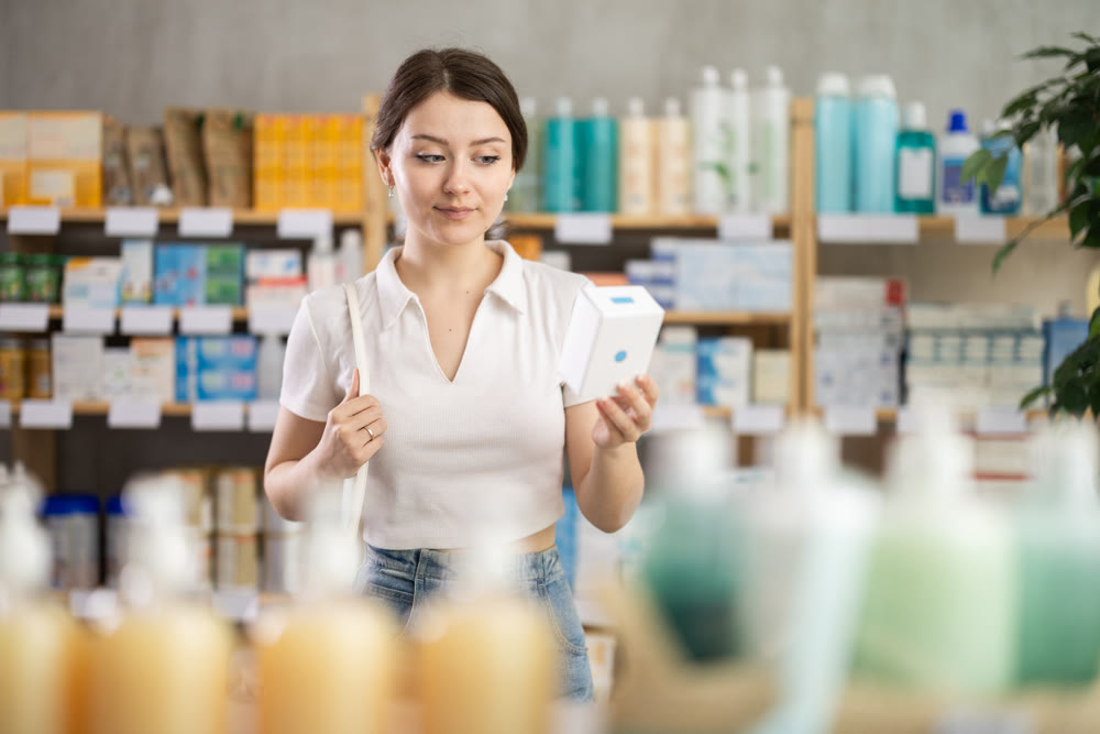 Girl in summer clothes looking for medicine in pharmacy