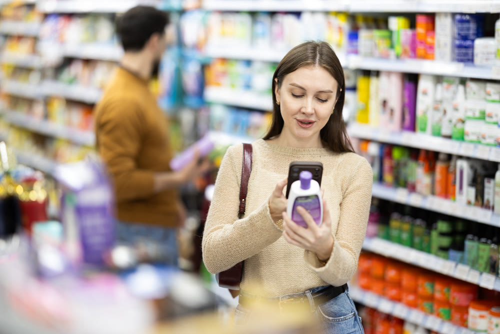 Young woman scanning QR code on care products