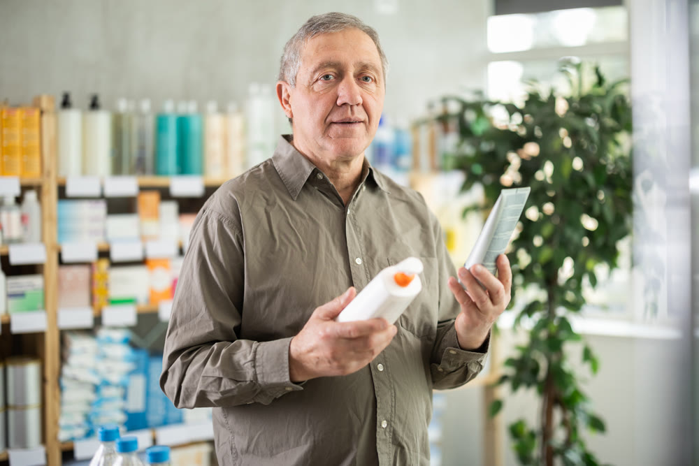 Older man choosing skincare products in pharmacy