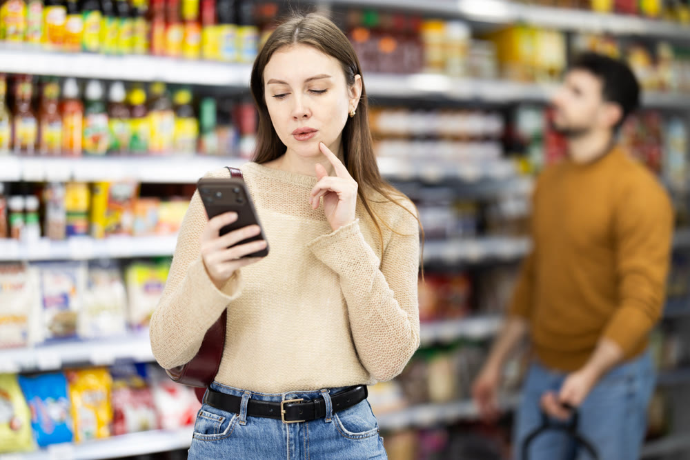 In store, girl type on mobile phone, walks around trading floor and chats in messenger