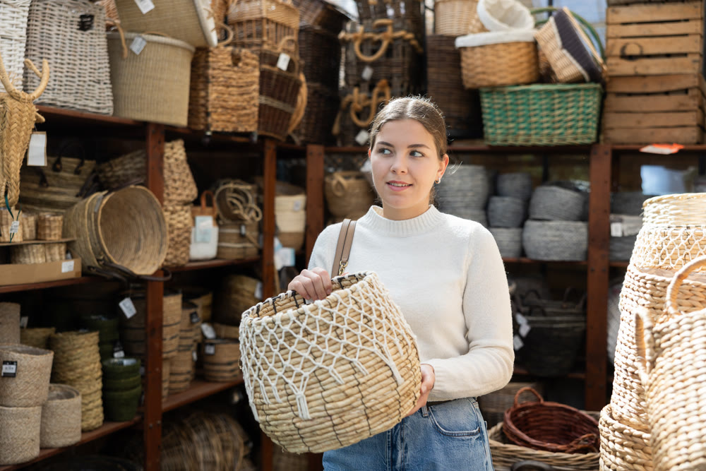 Girl looks at wicker basket in store.