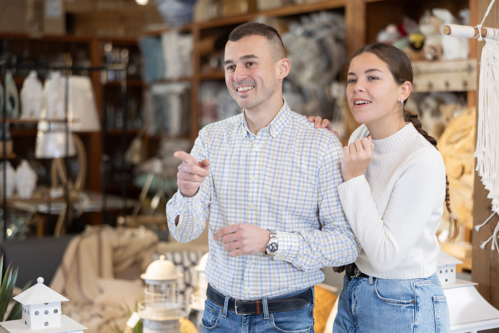 Couple man and woman choose furniture in store