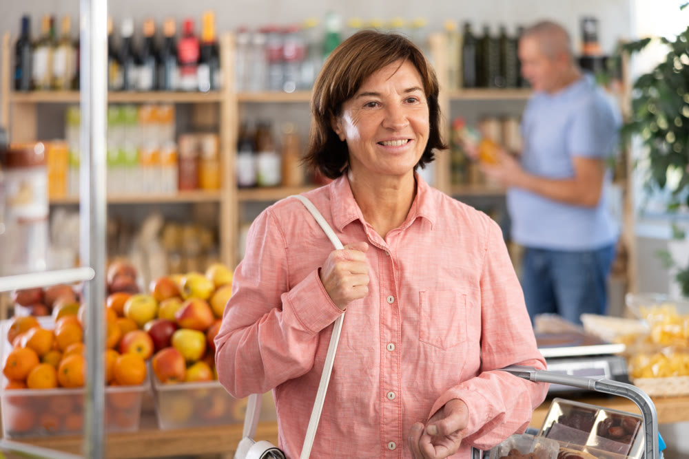 Elderly woman choosing food in grocery store