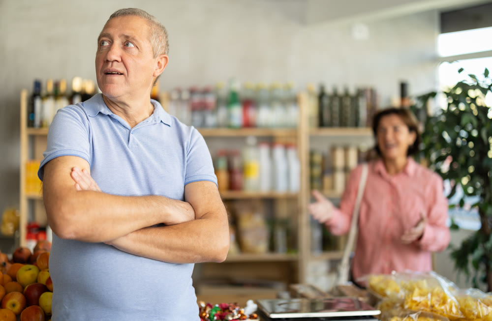 Family quarrel between elderly husband and wife in grocery supermarket. Woman screams at her husband