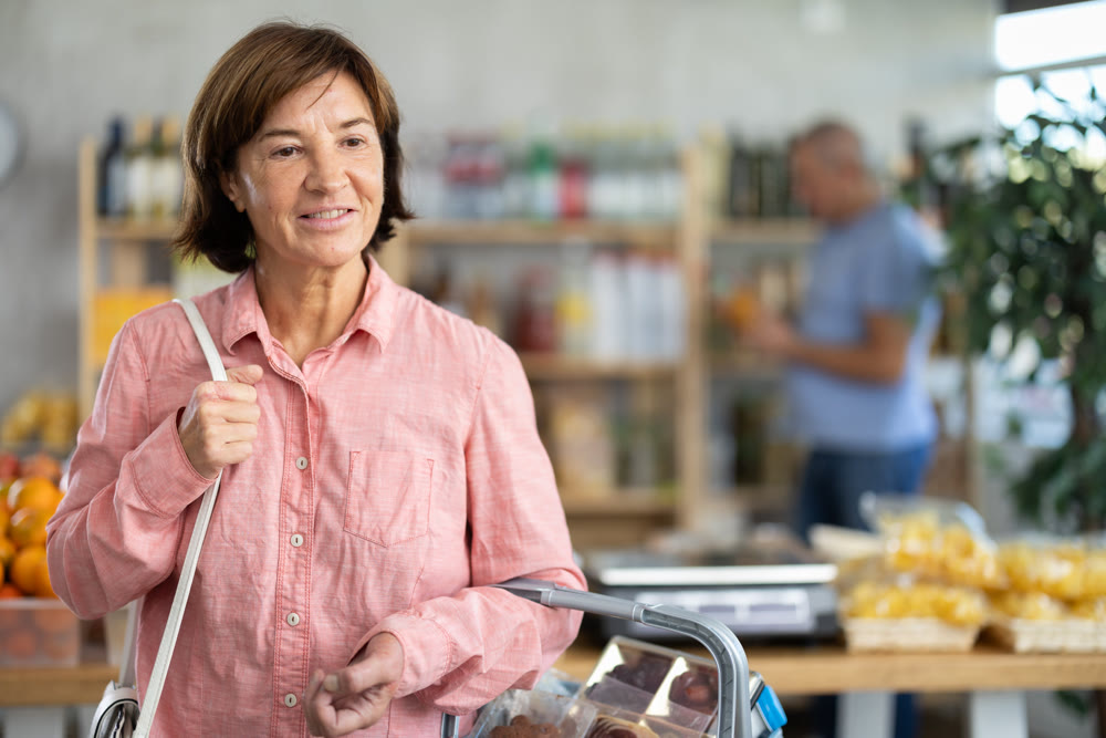 Family purchase of product in supermarket - woman buys anything on the shelves, man buys juice